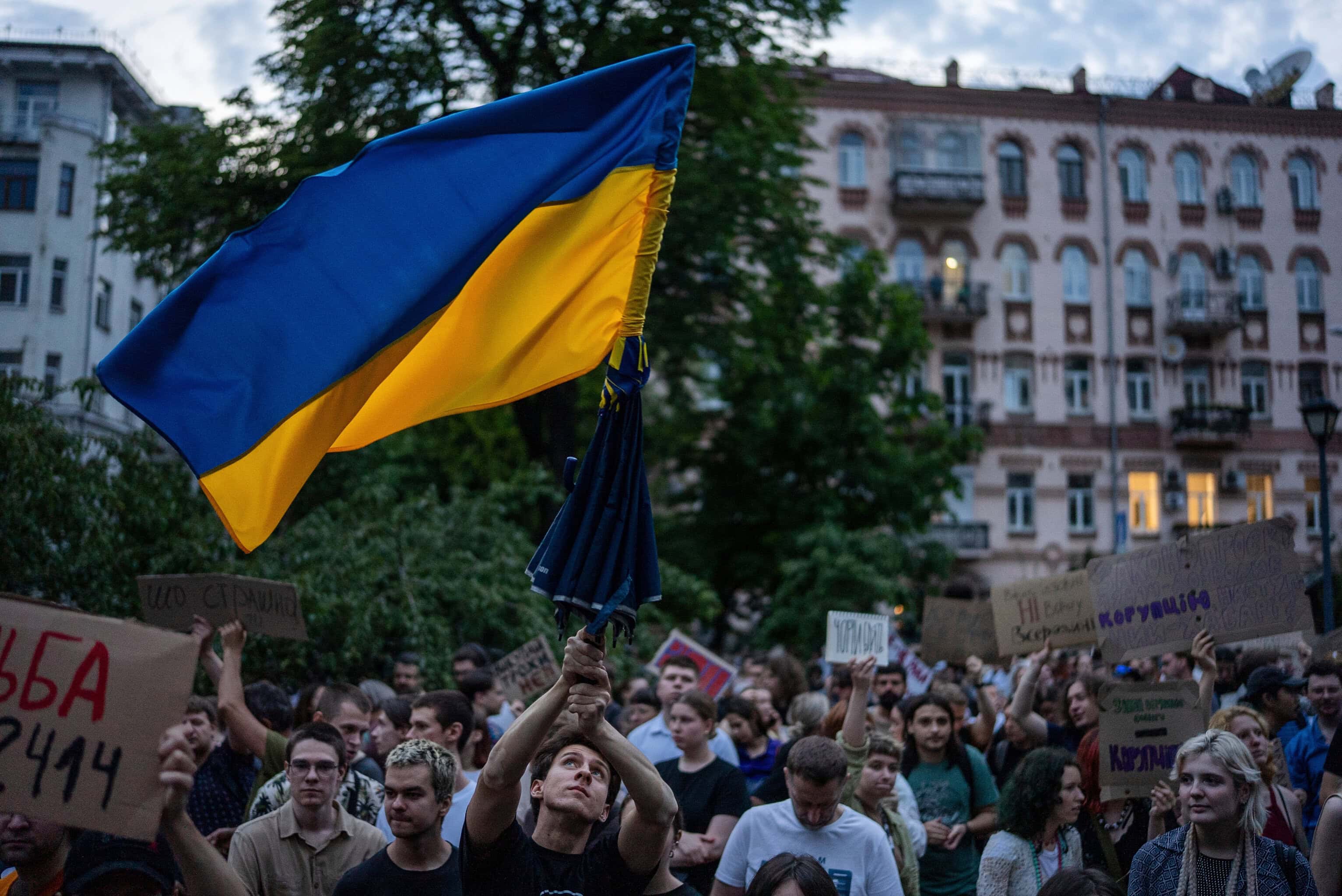 Muž máva vlajkou počas protestu proti zákonu zameranému na protikorupčné inštitúcie v centre Kyjeva, Zdroj: (TASR/AP Photo/Alex Babenko)