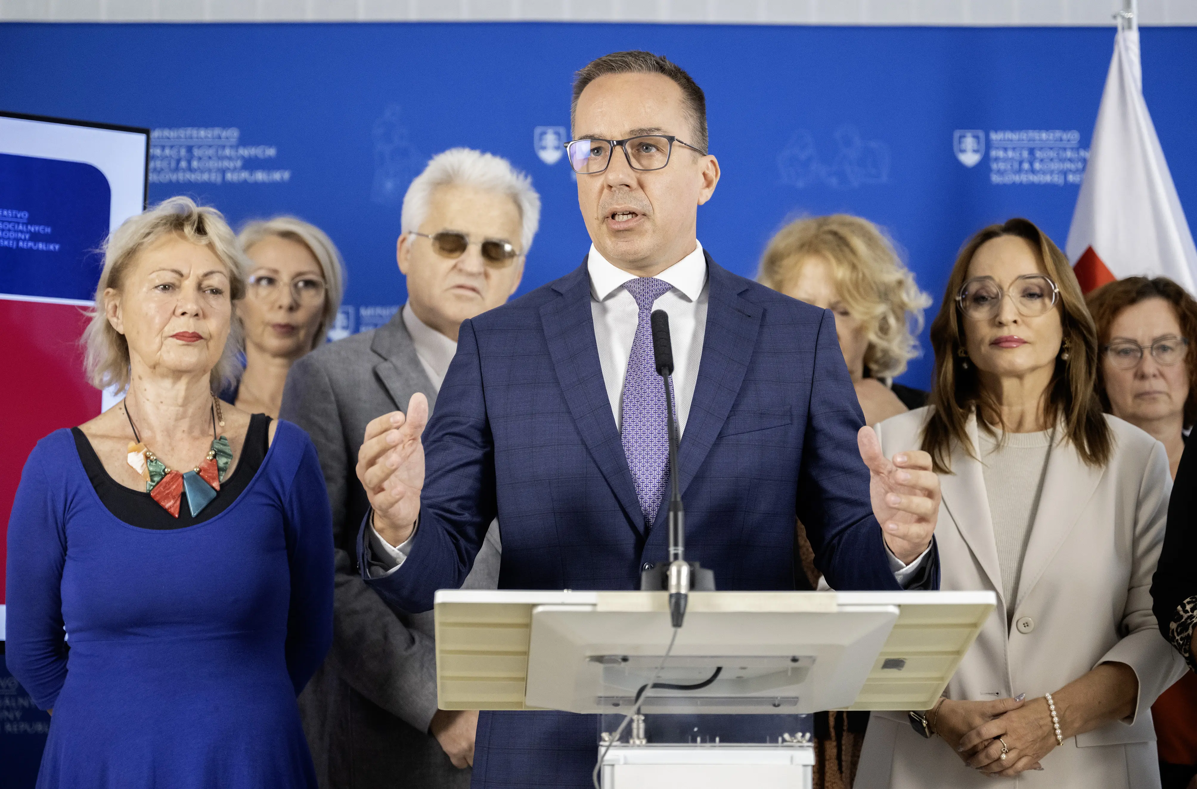minister práce, sociálnych vecí a rodiny SR Erik Tomáš (Hlas-SD), zľava v pozadí podpredsedníčka Komory opatrovateliek Slovenska Iveta Ždiľová, Lýdia Brichtová zo Sociofóra, predseda Národnej rady občanov so zdravotným postihnutím v SR Branislav Mamojka a predsedníčka Asociácie poskytovateľov sociálnych služieb (APSS) v SR Anna Ghannamová počas tlačovej konferencie na tému "Reforma financovania sociálnych služieb"  13. októbra 2025 v Bratislave. 