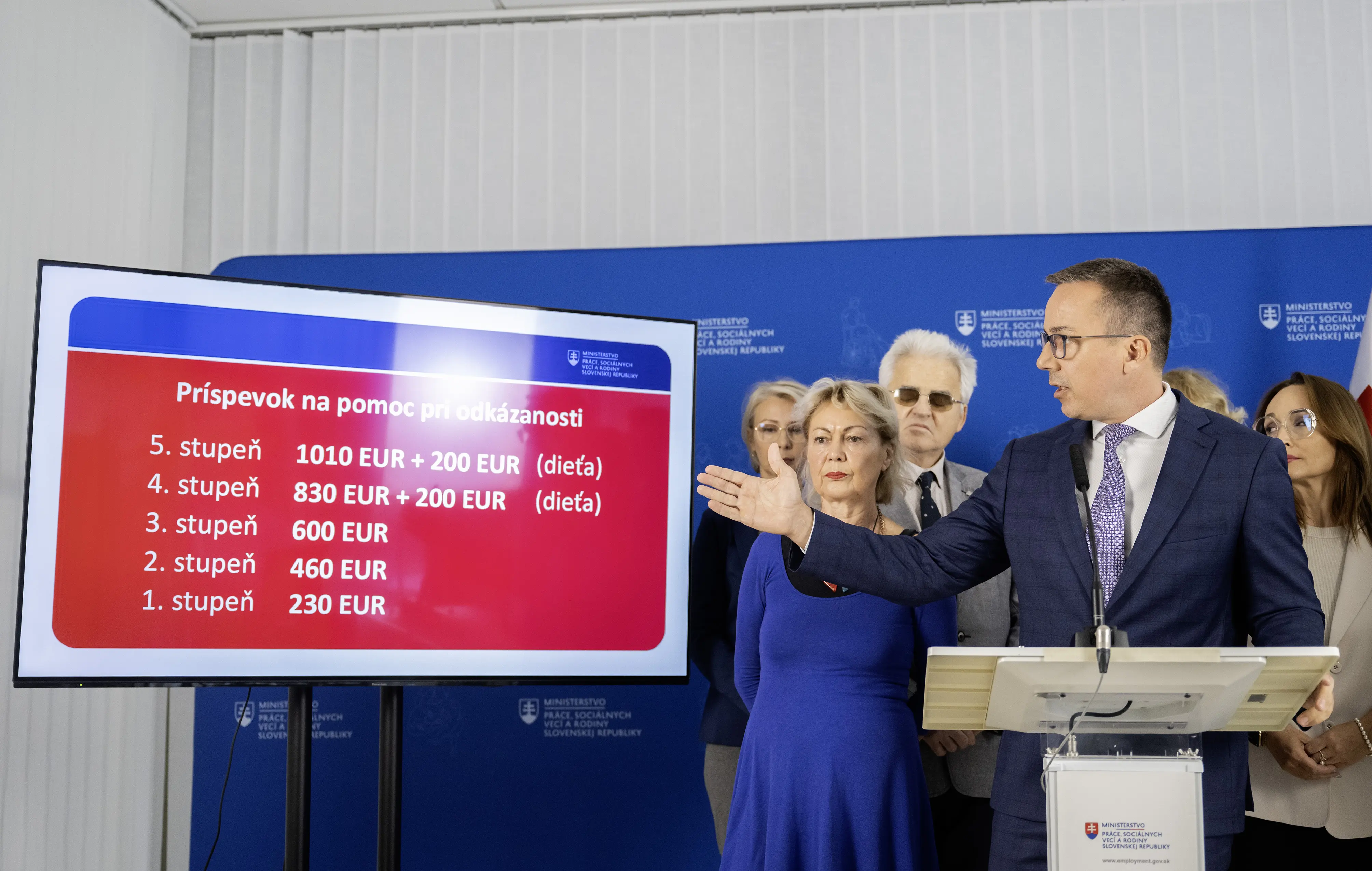 minister práce, sociálnych vecí a rodiny SR Erik Tomáš (Hlas-SD), zľava v pozadí podpredsedníčka Komory opatrovateliek Slovenska Iveta Ždiľová, Lýdia Brichtová zo Sociofóra, predseda Národnej rady občanov so zdravotným postihnutím v SR Branislav Mamojka a predsedníčka Asociácie poskytovateľov sociálnych služieb (APSS) v SR Anna Ghannamová počas tlačovej konferencie na tému "Reforma financovania sociálnych služieb"  13. októbra 2025 v Bratislave. 